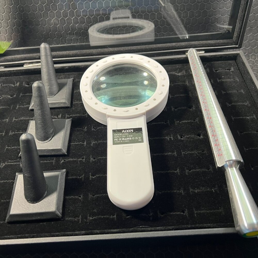 3 ring sizers 1 magnifying glass and 1 ring Holder